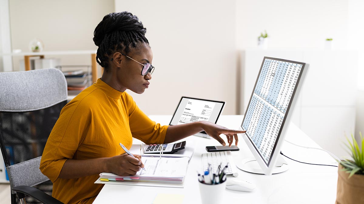 A woman calculates her breal-even point on a large monitor