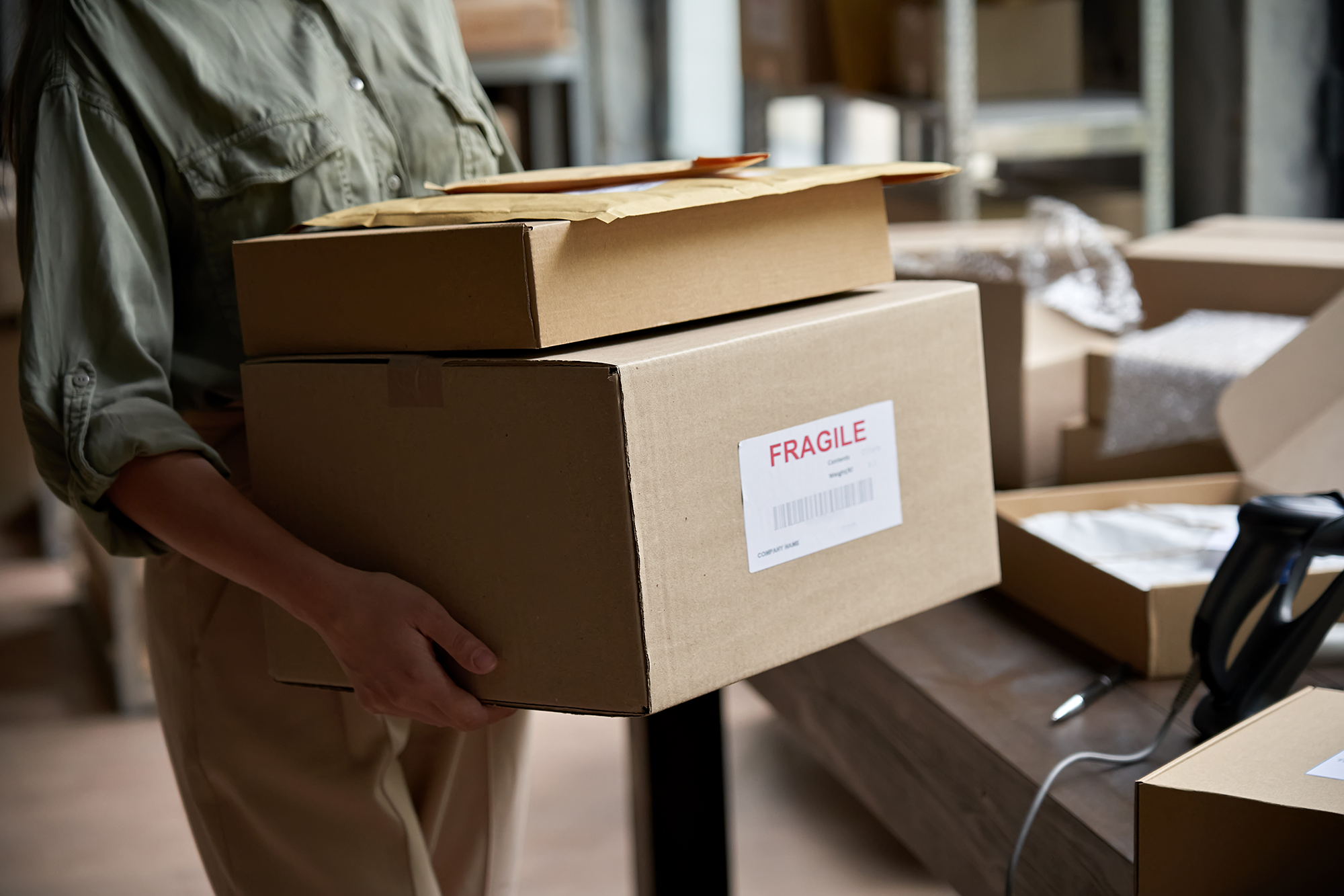 ecommerce_business_models A woman carries cardboard boxes to ship as part of her ecommerce business