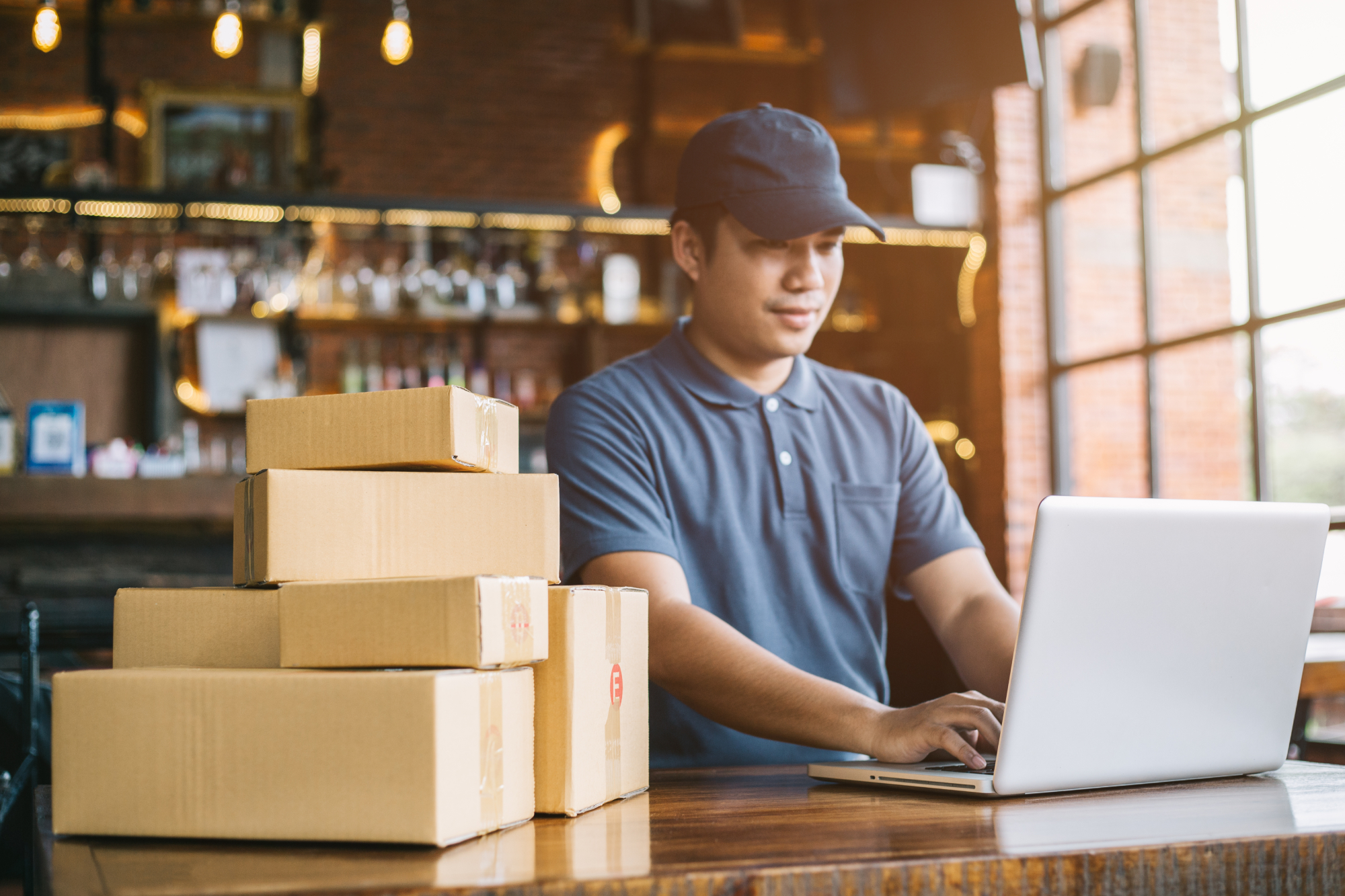 how_to_market_your_ecommerce_business A young man in a cap works on a laptop to market his ecommerce business